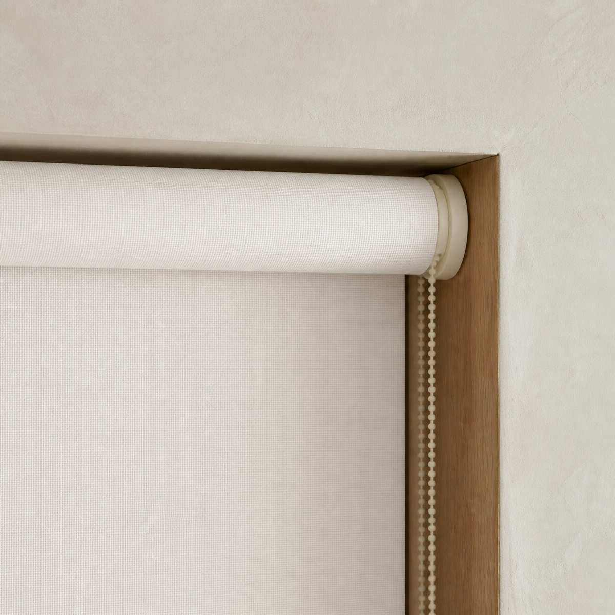 Close crop of a roller blind tube and bracket at the top of a window.