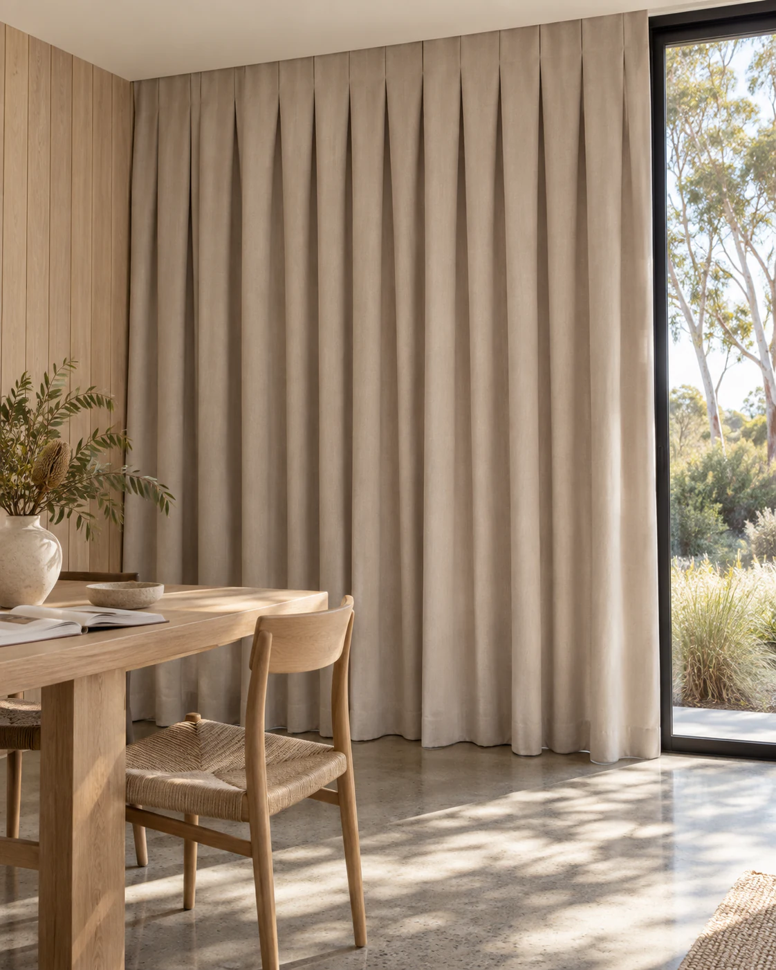 Oatmeal reverse-pleat curtains with a neat flat heading in a timber-panelled coastal room.
