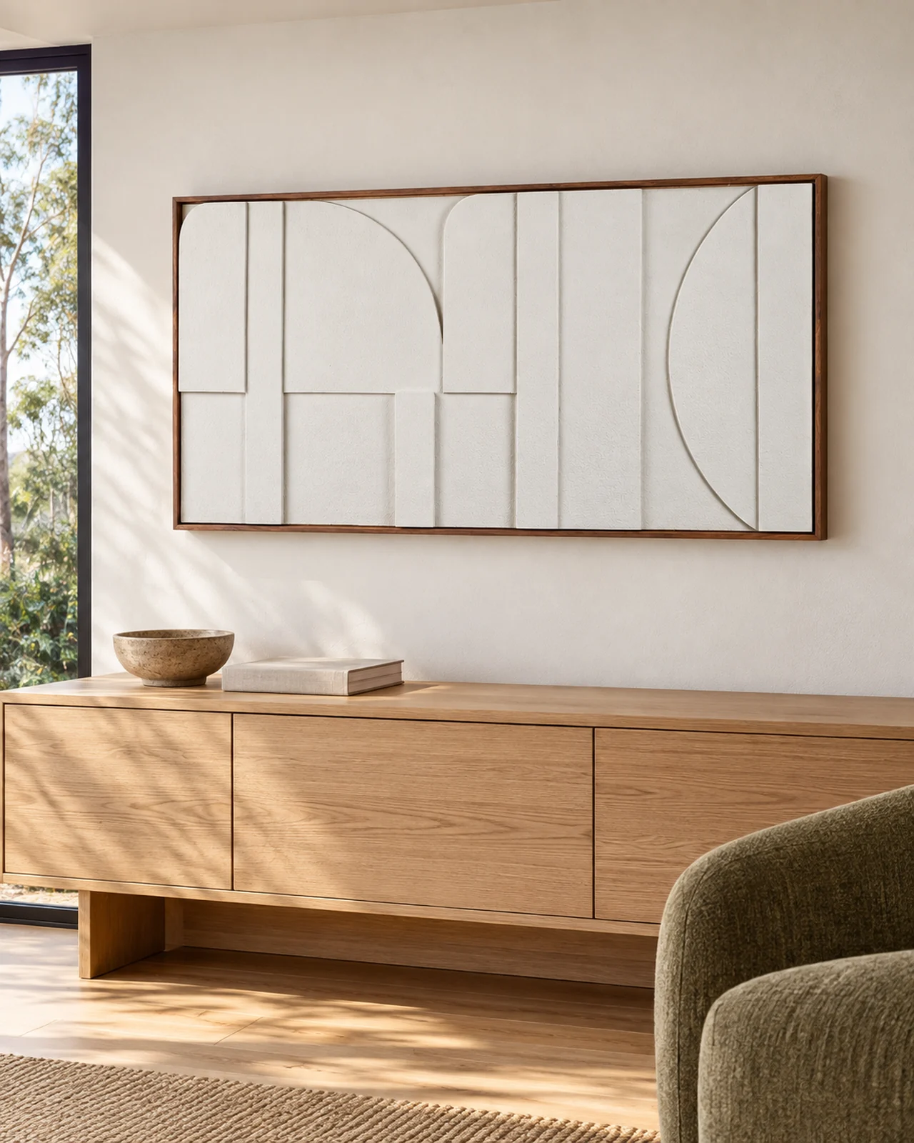 Framed geometric relief artwork above an oak sideboard in a warm living room